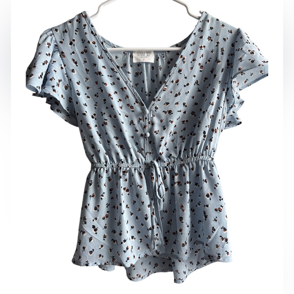 Blue blouse with flowers all over it